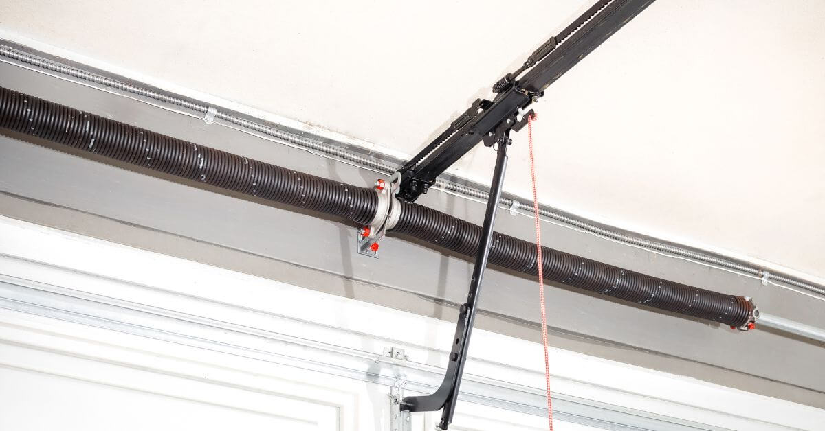 Torsion spring mounted above garage door